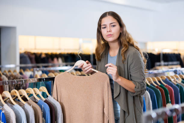 istock Young woman choosing knitted sweater in store 1486642334