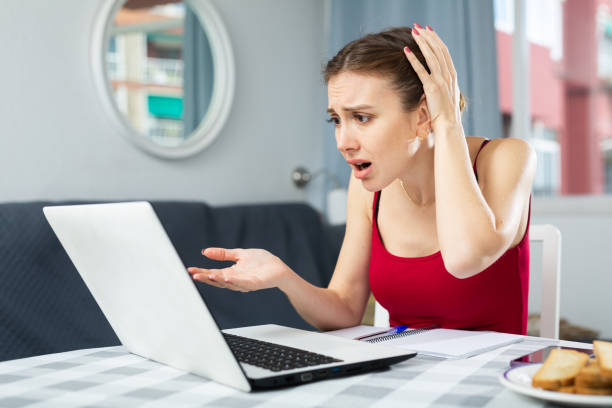istock Disappointed woman with laptop at home 1486643406