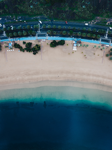 The golden sand of Playa de las Teresitas stretches for almost one mile (1.5 kilometres); palm trees sway in a gentle warm sea breeze and the beautiful calm waters are perfect for taking a dip to cool off. Welcome to what is widely regarded as one of the nicest beaches in the north of Tenerife.\n\nSitting below the Anaga Mountains just outside of the capital Santa Cruz in the village of San Andrés, this beach is captivating and a great place to chill out and enjoy the sunshine. Please bear in mind that a place with such a good reputation tends to get fairly busy, especially at weekends. Even with its popularity, Playa de las Teresitas remains unspoiled and could easily be mistaken for a part of the Caribbean coastline.