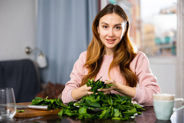 istock Young woman sorts fresh spinach 1486643574