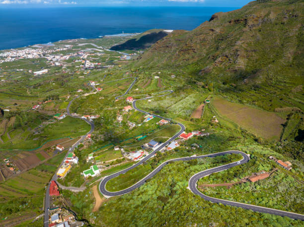 Aerial view of winding roads above El Palmar, Beunavista del Norte and Los Silos in Parque Rural de Teno, Tenerife, Spain This mountainous area, at over 1,300 metres above sea level, covers the extreme eastern part of Tenerife and is almost completely surrounded by the sea. In fact, in the distant past Teno was a small separate island, which then joined with other sections to become a single mass of land that is today called Tenerife. This relative geographic isolation has meant the ravines and narrow valleys have conserved a unique biodiversity, architecture and set of customs and habits, which you probably won't find in the Tenerife of mass tourism and populated resorts. teno mountains photos stock pictures, royalty-free photos & images