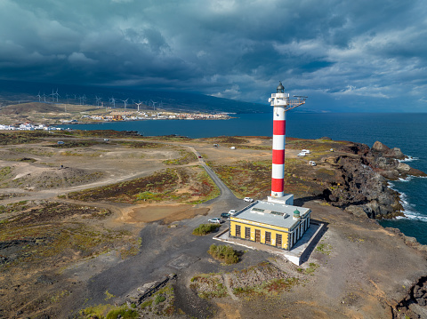 Landscape shot of cape recife lighthouse with reflection in the water on a clear blue sky day in summer