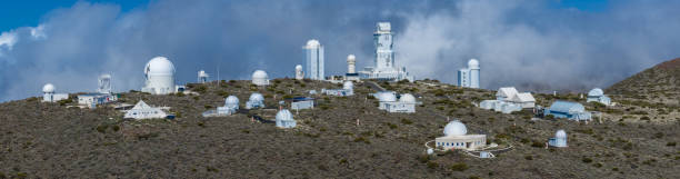 Aerial Panoramic View of Teide Observatory (Observatorio del Teide) and Institute of Astrophysics of the Canary Islands, Tenerife, Spain Teide Observatory, IAU code 954, is an astronomical observatory on Mount Teide at 2,390 metres, located on Tenerife, Spain. It has been operated by the Instituto de Astrofísica de Canarias since its inauguration in 1964. observatory tenerife canary islands el teide national park stock pictures, royalty-free photos & images