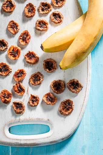 Sweet and tasty sun dried banana as a sweet snack. Dried fruits in the sun in the garden.