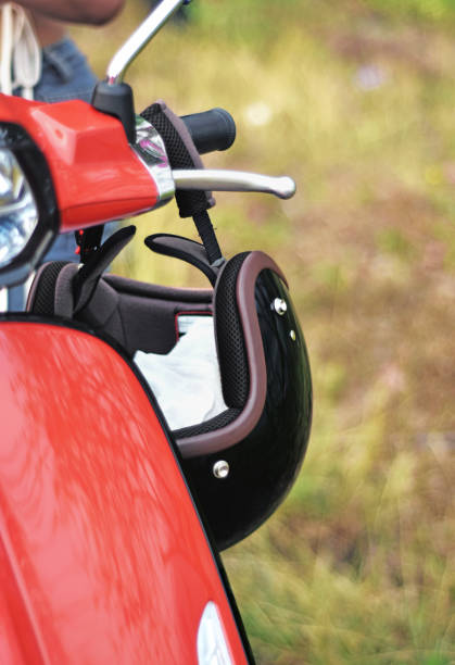 istock Black motorcycle helmet hanging on handlebars of red motorcycle 1486651499