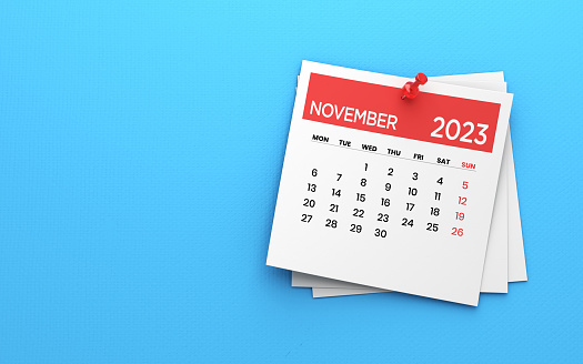 3d illustration. 2023 Post it note November Calendar and Red Push Pin on Blue Paper Background stock photo. Calendar and reminder concept.