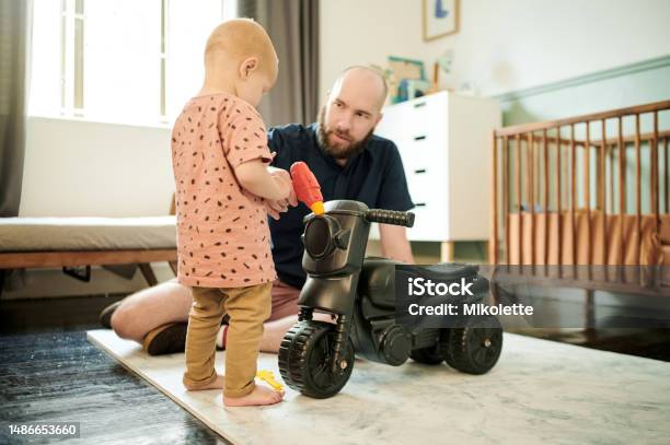 Dad Baby And Living Room Walking For Motor Skills Learning And Growth In A Home House Family And Young Kid With Father Playing With Toy Car With Love Parent Support And Care For Toddler Stock Photo - Download Image Now