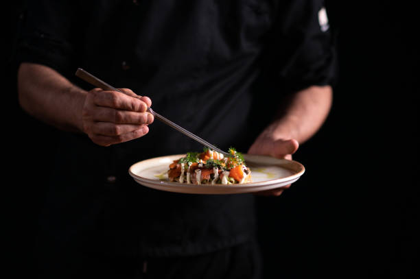 istock A male chef decorating a plate of crostini di salmone e avocado 1486654395