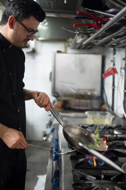 istock A male chef in restaurant kitchen at stove with pan 1486654579