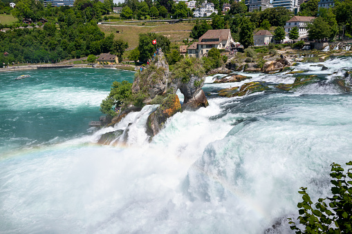 Zurich, Switzerland - July 11, 2022: Tourists get a close look at the Rhine Falls from the observation deck in the middle of the waterfall on the Rhine River between Zurich and Schaffhausen, Switzerland.
