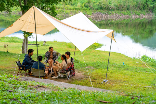 istock Group of Asian people having breakfast drinking coffee while camping together at nature park. 1486659483