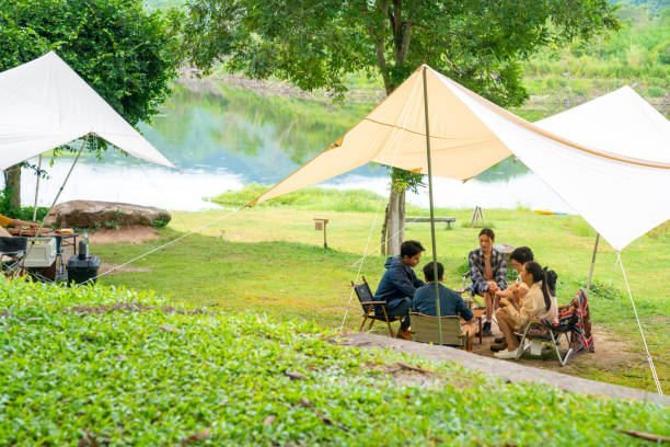 istock Group of Asian people having breakfast drinking coffee while camping together at nature park. 1486659506