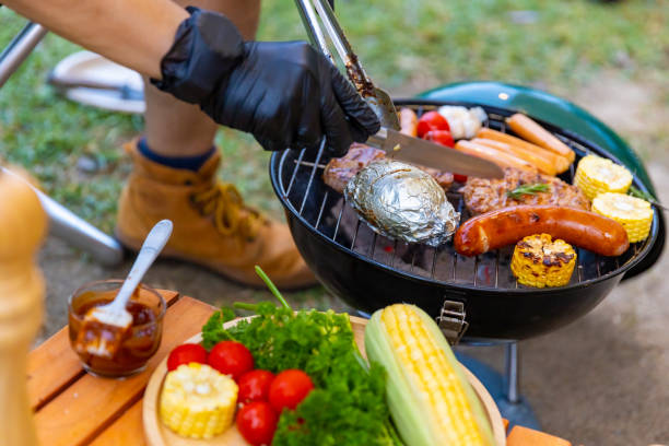 istock Group of Asian people cooking and having dinner while camping together at summer sunset. 1486660394