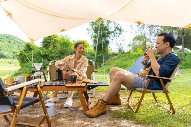 istock Group of Asian people having breakfast drinking coffee while camping together at nature park. 1486660463