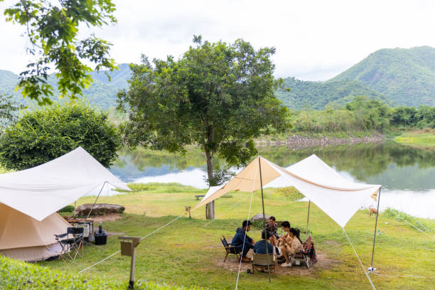 istock Group of Asian people having breakfast drinking coffee while camping together at nature park. 1486660467