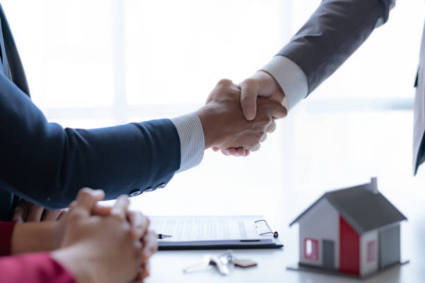 istock Real estate agent shaking hands with a client to sign a home purchase contract and congratulate the client. 1486660696