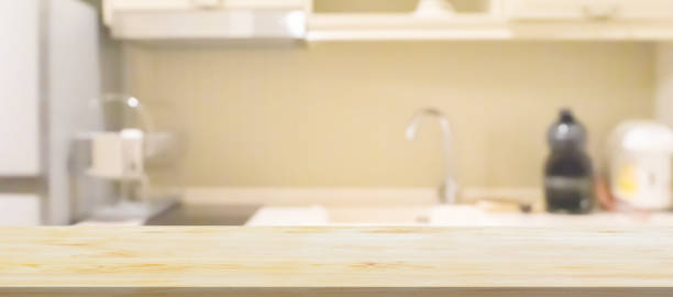 istock Black wood counter top with blurred kitchen background 1486662450
