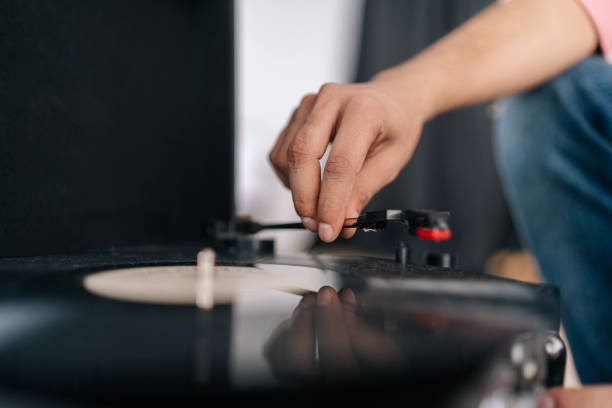 istock Close-up hands of unrecognizable young man adjusting head old record player and vinyl discs. Music lover male listening to classical music at home. 1486662615