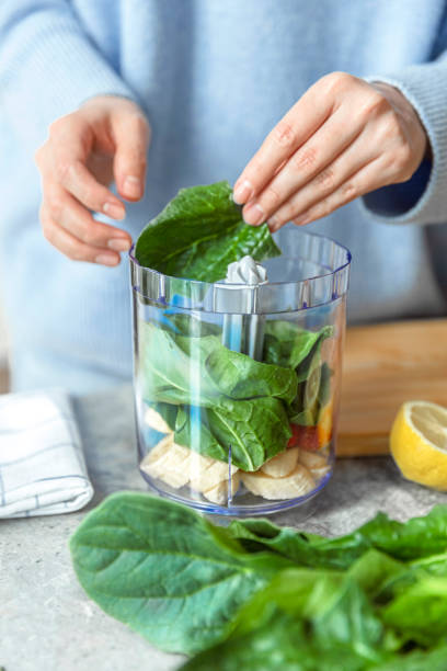 istock Woman making green smoothie. 1486663637