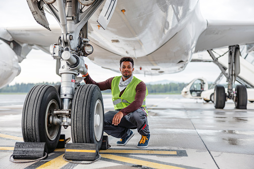 An aircraft engineer repairing and maintaining jet airplane.