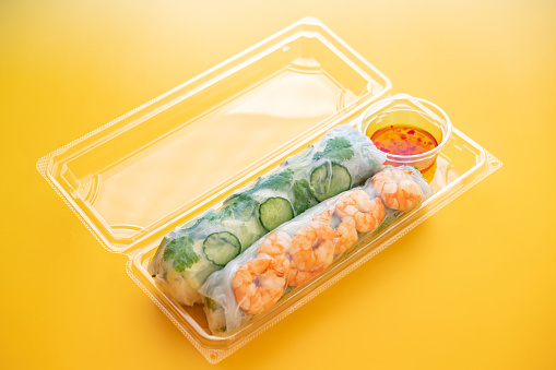 Spring Rolls and Sweet Chili Sauce in a Plastic Container, Yellow Background