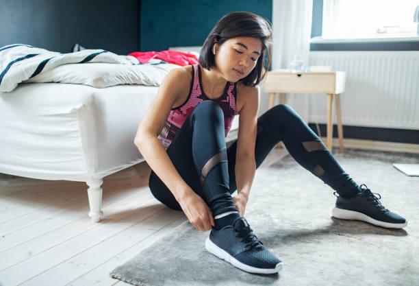 istock Young woman tying her shoelaces and getting ready to go exercise 1486683331