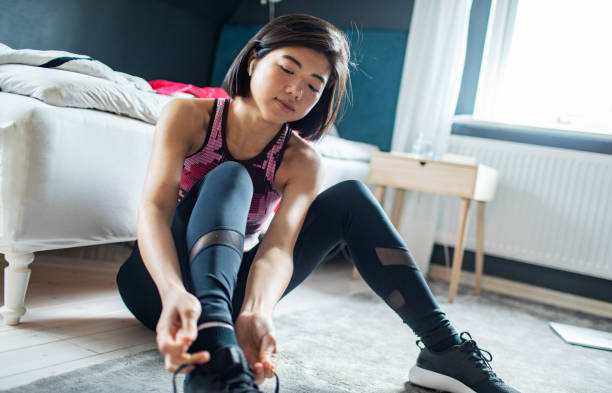 istock Young woman tying her shoelaces and getting ready to go exercise 1486683416