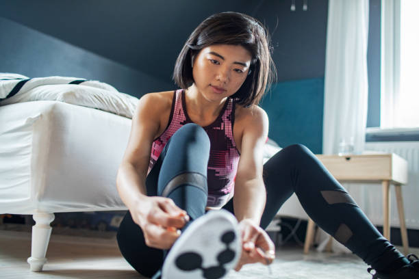 istock Young woman tying her shoelaces and getting ready to go exercise 1486683517