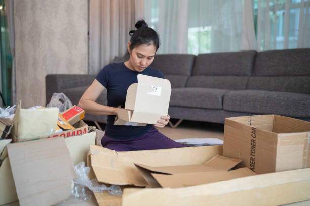 istock A woman deflating cardboard boxes and stacking them together 1486688956