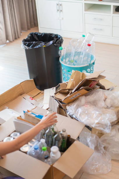 istock Human hand sorting recycling stuffs into a cardboard box neatly filled with recyclable wastes 1486689196