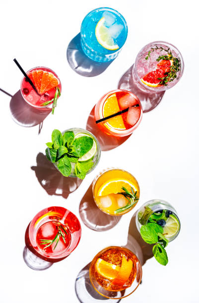 istock Summer cocktails drinks set. Assortment of multicolored strong and low alcoholic beverages for cocktail party. White background, hard light, shadows pattern, top view 1486696294