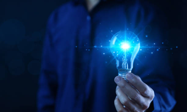 istock businessman holding a blue light bulb Digital technology imagines creative ideas. 1486701387