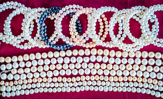 Cultured pearl necklaces against red cloth background at a shop in Ha Long City, Vietnam