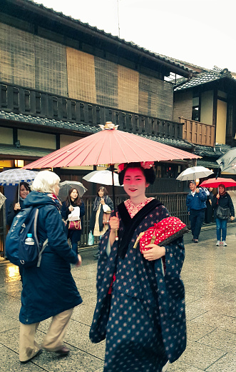 Kyoto, Japan in April 2019. A geisha wearing a kimono walking in the Gion district. Gion is located in Higashiyama District, Kyoto City. This district is inhabited by many geiko or female artists.