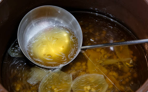Broth movement in the ladle. Chicken soup with celery, ginger, and garlic.