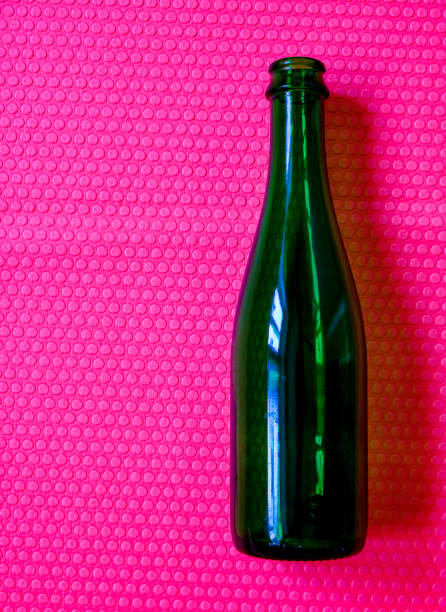 istock One empty bottle. Bright pink background. Beverage container. Green glass. 1486705992