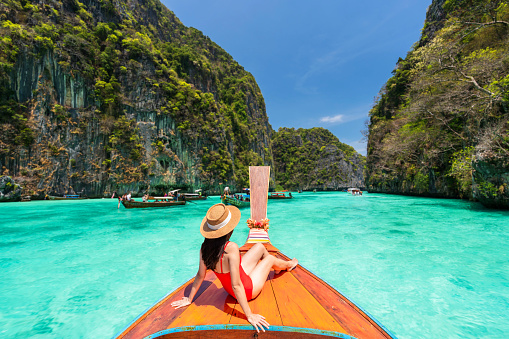 Young woman traveler relaxing and enjoying at Pi leh Lagoon at ko Phi Phi lay island in Krabi, Thailand, Summer vacation and Travel concept