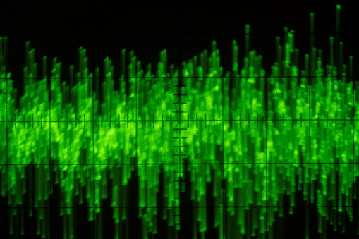 Audio signal on oscilloscope screen. Communication and electronics. Close up, blurred focus