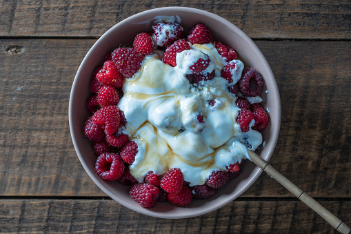 istock Natural organic yogurt with fresh red raspberries and cottage cheese for breakfast, top view, close up 1486719170