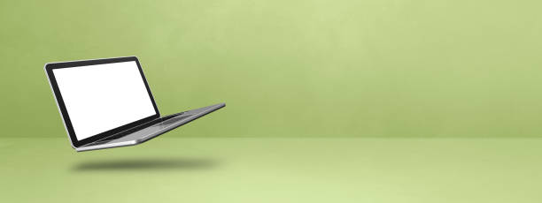 istock Floating computer laptop isolated on green. Horizontal banner background 1486724373