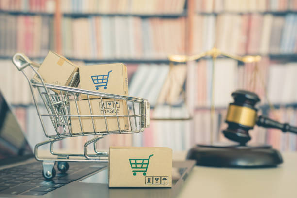 Consumer rights and consumer protection, business law concept : Shopping basket, shopping boxes and a shopping cart on a laptop computer with judge gavel, balance sale of justice and bookshelf behind. Consumer rights and consumer protection, business law concept : Shopping basket, shopping bags and a shopping cart on a laptop computer with judge gavel, balance sale of justice and bookshelf behind. human rights act stock pictures, royalty-free photos & images