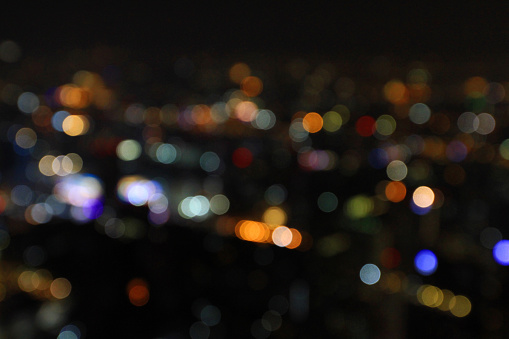 Blurred colorful light Bokeh of Bangkok on dark night for background. Defocused technique. Abstract wallpaper of life in city or country concept.