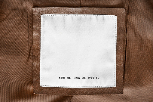 Size XL clothing label closeup on brown fabric
