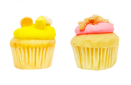 Cupcake with strawberry cream and brown sugar topping and yellow or pineapple cupcake isolated on white background with clipping path. Fresh sweet bakery baked and homemade. Colorful dessert.