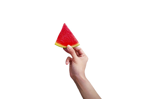 Woman's hand holding sliced piece of fresh watermelon isolated on white background with clipping path