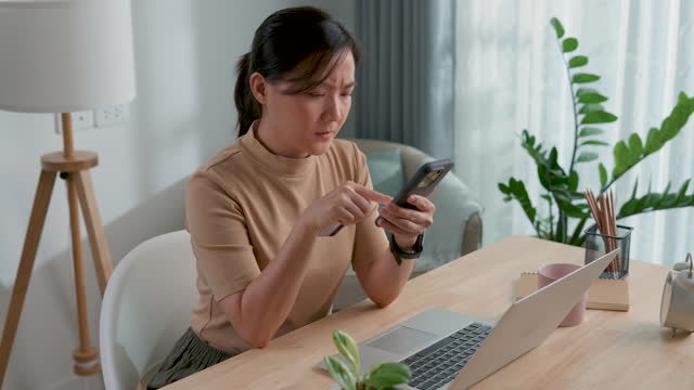 Asian woman using smartphone and credit card feel confused have a problem with payment.