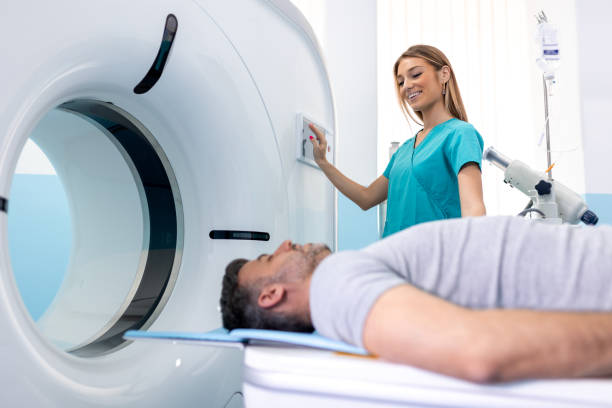 doctora que observa a un paciente sometido a una tomografía computarizada. médico en uniforme usando una máquina de tomografía con paciente acostado en el hospital - cat scan mri scanner healthcare and medicine medical exam fotografías e imágenes de stock