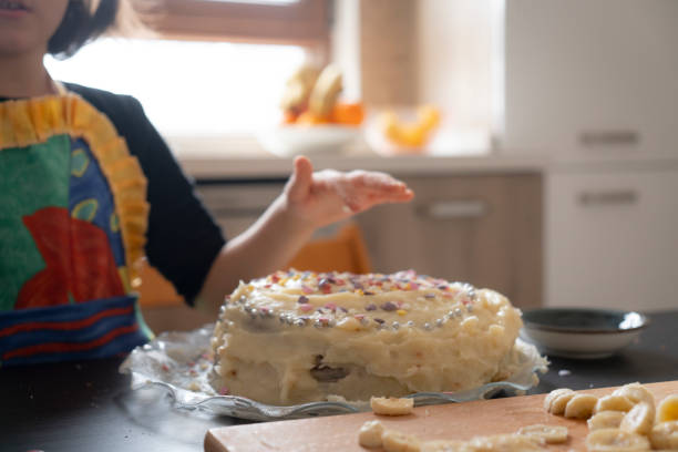小さな女の子はバースデーケーキに振りかけます。 - cake birthday domestic kitchen child ストックフォトと画像