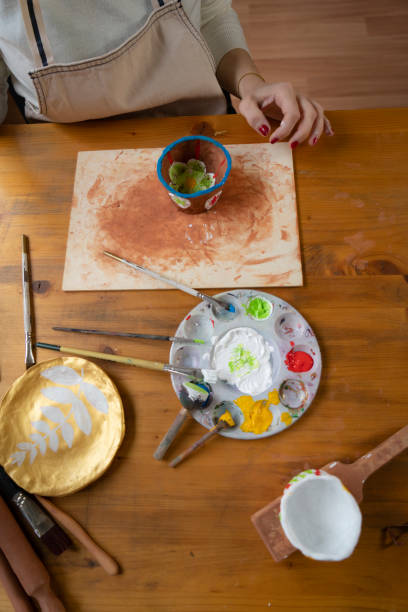 istock Female hands painting a pottery 1486739418