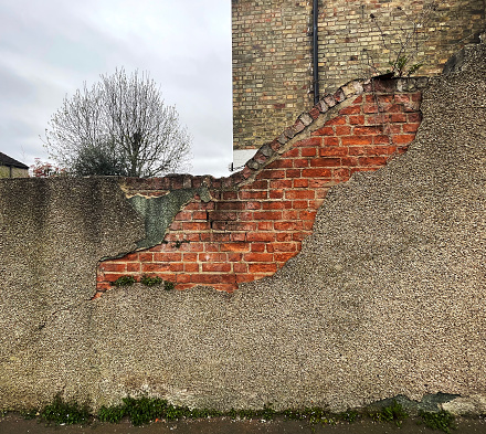 Old brick wall with damaged rendering